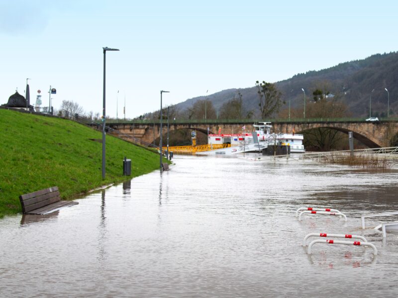 Photo of a flooding river with bridge in the distance