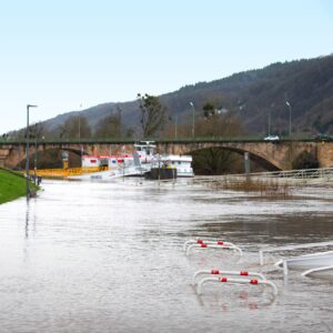 Photo of a flooding river with bridge in the distance