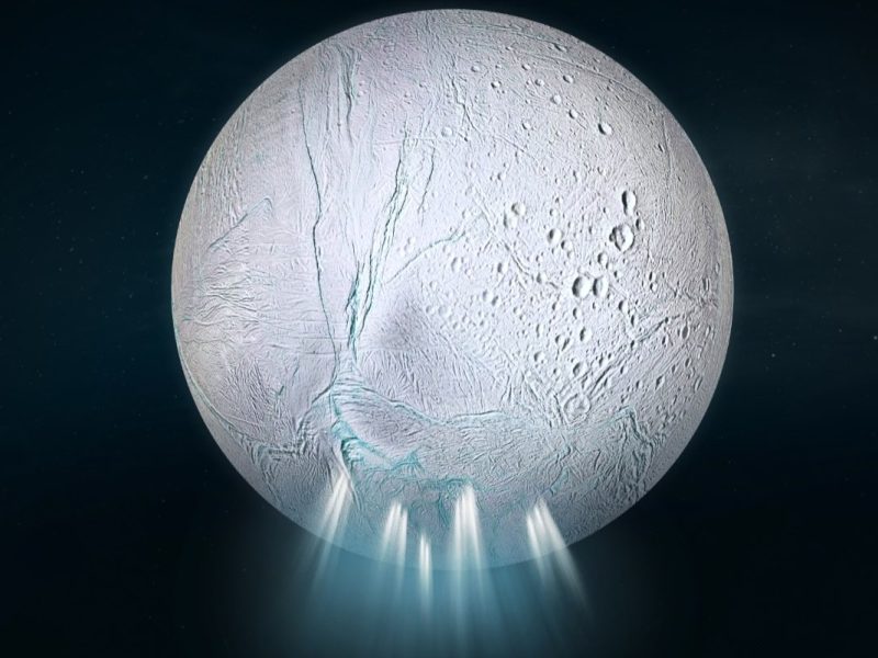 artist's impression of Saturn's icy moon Enceladus. with a very white surface covered in what looks like scars or cracks. Emanating from cracks at the bottom of the moon are white jets, with a fuzzy blue glow around them.
